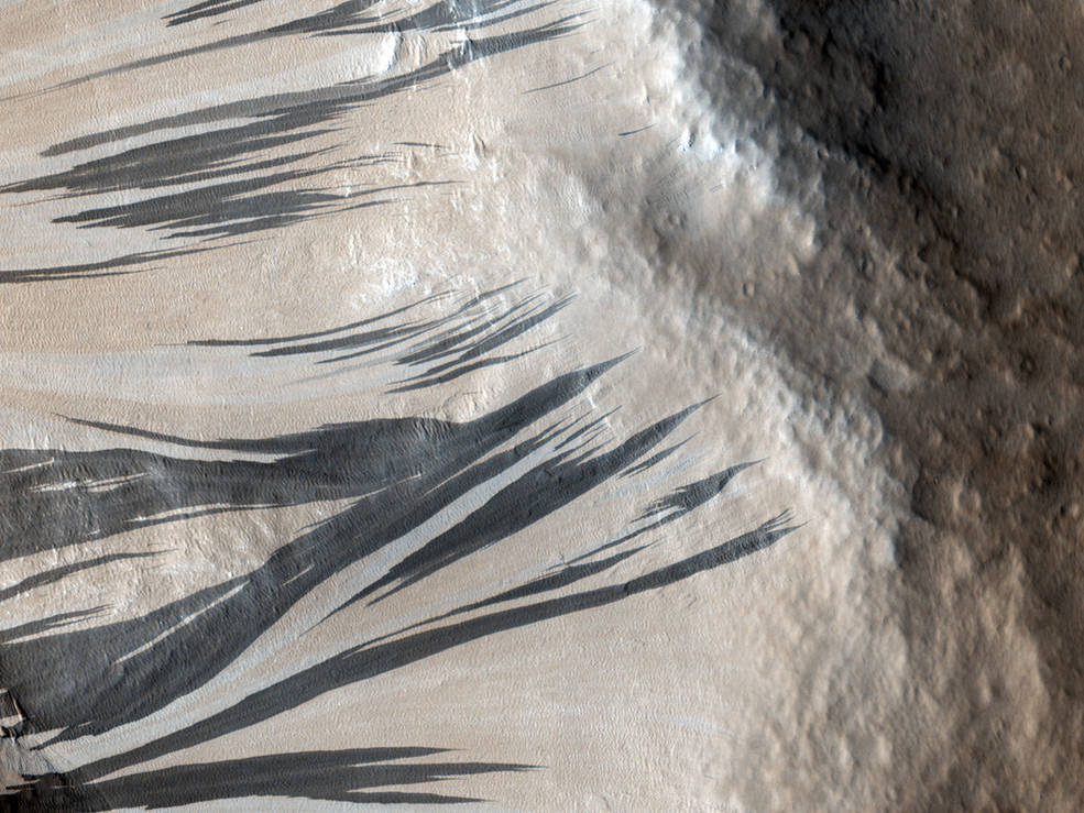 这些深色条纹，也被称为“斜坡条纹”，是由火星上一个名为阿克龙-福斯的区域的尘埃雪崩引起的。2006年12月3日，美国宇航局火星勘测轨道飞行器上的 HiRISE 相机捕捉到了它们。