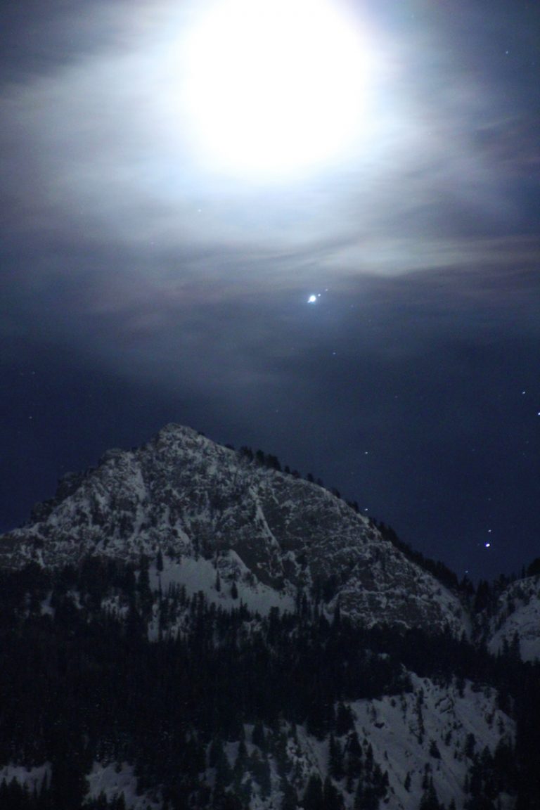 拍摄于2019 年 2 月 27 日的图像，图中：当月亮从山脉升起时，可以看到木星及其三个最大的卫星。 9 月 26 日星期一，在木星对冲期间，观星者应该也可以观测到类似的景象。图源：NASA