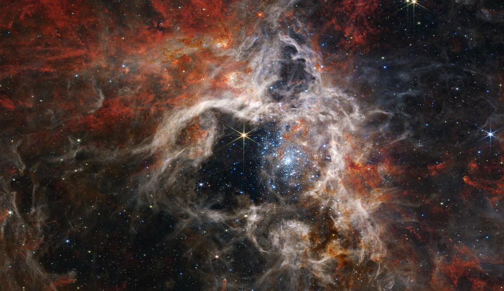 在这张横跨340光年的马赛克图像中，韦伯的近红外相机（NIRCam）以新的光线展示了狼蛛星云恒星形成区域，包括数万颗以前被宇宙尘埃笼罩的从未见过的年轻恒星。最活跃的区域似乎闪耀着巨大的年轻恒星，呈现出淡蓝色。